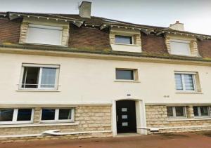 a large white house with a black door at Appartement 3 étoiles de 63m2 in Cabourg