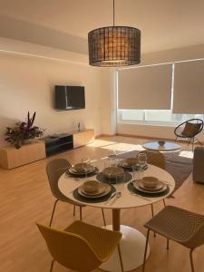 a living room with a table and chairs and a television at Soho Moraleja III in Alcobendas