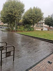 a bench sitting in the rain on a street at T1 bis centre ville d'Aurillac in Aurillac
