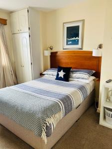 una camera con un grande letto con testiera in legno di The Waterside B&B a Westport