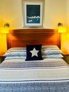a bed with a star pillow on top of it at The Waterside B&B in Westport