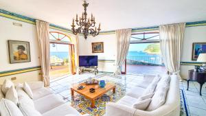 a living room with white couches and a table at Villa Costa degli Dei in Furore