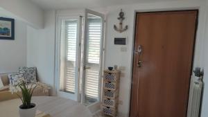 a room with a table and a door with shutters at Casa Vacanze da Mary in Porto Recanati