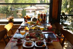 una mesa con platos de comida y vasos de zumo de naranja en Roma Cave Suite, en Göreme