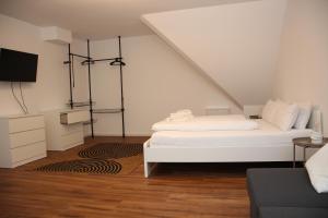una stanza bianca con un letto e una tv di Nibelungen Apartments - Worms-Hochheim a Worms