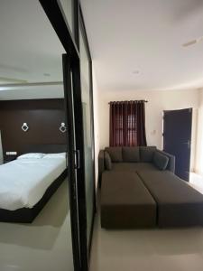 a bedroom with a bed and a couch at Town Hub in Valāncheri