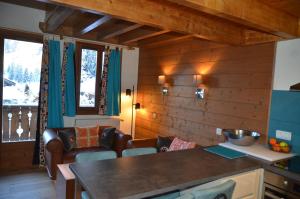 eine Küche mit Holzwänden sowie einem Tisch und Stühlen in der Unterkunft Hôtel et Chalet Au Coin Du Feu Chilly Powder in Morzine