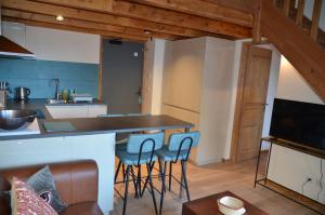 eine Küche mit einer Theke und Hockern in einem Zimmer in der Unterkunft Hôtel et Chalet Au Coin Du Feu Chilly Powder in Morzine