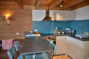 a kitchen with a table and chairs in a room at Hôtel et Chalet Au Coin Du Feu Chilly Powder in Morzine