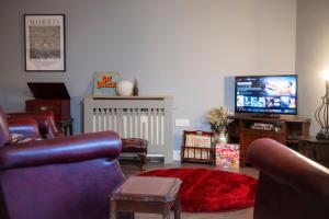 a living room with couches and a flat screen tv at Spacious 2 bed apartment in Canterbury