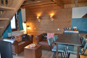 ein Wohnzimmer mit einem Sofa und einem Tisch in der Unterkunft Hôtel et Chalet Au Coin Du Feu Chilly Powder in Morzine