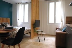 uma pequena sala de estar com uma cama e uma mesa em Superbes Appartements Modernes et Neufs em Bagnols-sur-Cèze