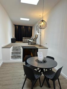 - un salon avec une table, des chaises et une cheminée dans l'établissement luxe pas gerenoveerd monumentaal appartement, à Maastricht
