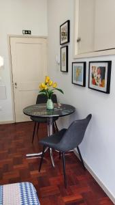 una mesa y una silla con un jarrón de flores. en Apartamento Burgo " A Preferida ", en Funchal