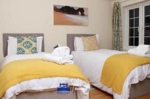 a bedroom with two beds with yellow and white sheets at 3 Bedroom House For Contractors By Beds Away Short Lets & Serviced Accommodation Oxford With Free Parking for 2 Cars in Oxford +6 photos
