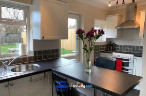 a kitchen with a vase of flowers on a counter at 3 Bedroom House For Contractors By Beds Away Short Lets & Serviced Accommodation Oxford With Free Parking for 2 Cars in Oxford