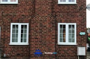 two windows on the side of a brick building at 3 Bedroom House For Contractors By Beds Away Short Lets & Serviced Accommodation Oxford With Free Parking for 2 Cars in Oxford