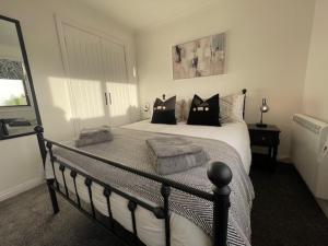 sypialnia z łóżkiem z czarno-białymi poduszkami w obiekcie Coll Farm House w mieście Back