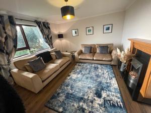 a living room with a couch and a fireplace at Coll Farm House in Back