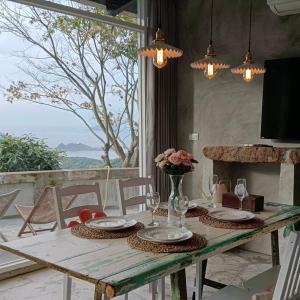 a wooden table with plates and flowers on top of it at Sunny Room in Jiufen