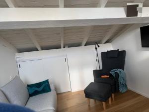 ein Wohnzimmer mit einem Sofa und einem Stuhl in der Unterkunft Via Pia 29-7 in Savona