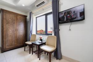 a living room with a table and chairs and a window at Đức Hiếu 1 in Hanoi