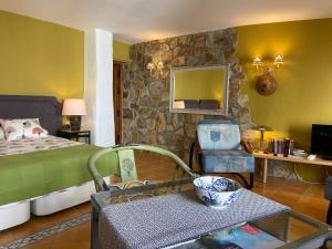 コンペタにあるCompeta Suitesの石壁のベッドルーム1室(ベッド1台付)