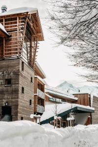 een gebouw bedekt met sneeuw naast een berg sneeuw bij Werdenfelserei in Garmisch-Partenkirchen