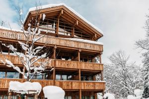 duży drewniany budynek pokryty śniegiem w obiekcie Werdenfelserei w Garmisch Partenkirchen