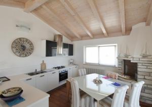 eine Küche mit einem Esstisch und eine Küche mit weißen Schränken in der Unterkunft Istrian villa with unique sea view in Lovrečica
