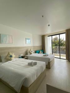 a hotel room with two beds and a balcony at HAYA Sea View Hotel Phu Quoc in Phú Quốc