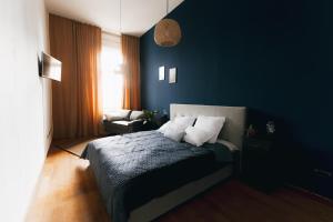 a bedroom with blue walls and a bed with white pillows at Central Blue Charm in Arad