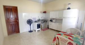 uma pequena cozinha com um frigorífico e um fogão em Francisca e Manoel em Boa Vista