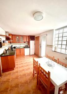 a large kitchen with a table and chairs in it at Apartamento en el Edificio Barlovento, situado en el centro de Alcossebre, a 150m del mar in Alcossebre