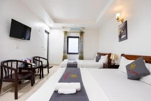 pokój hotelowy z dwoma łóżkami i telewizorem w obiekcie Đức Hiếu 1 w mieście Hanoi