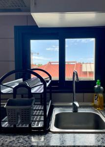 fregadero de cocina con tendedero de platos y ventana en Apartamento Burgo " A Preferida ", en Funchal