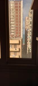 una ventana con vistas al océano y a los edificios en شارع الدير كليوباترا بجوار سيدي جابر الاسكندرية متفرع من البحر أمام الدير مباشرتا en Alexandria