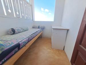 a small room with a bed and a window at pilipili bed house in Lamu