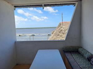 a window in a room with a view of the water at pilipili bed house in Lamu