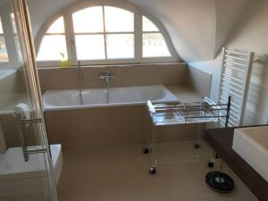 グロース・シュヴァンセにあるReetdachhaus Seasons mit Kamin & Saunaのバスタブと窓のあるバスルーム +17枚の写真