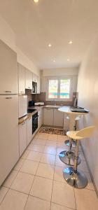 a kitchen with white appliances and a table and chairs at Villefranche center Bay & Port Sea view front in Villefranche-sur-Mer