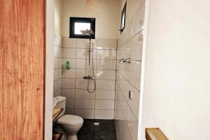a bathroom with a shower with a toilet and a television at Bungalow Ramena beach Antsiranana in Andjamen +25 photos