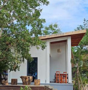 uma pequena casa branca com cadeiras laranjas em frente em Bungalow Ramena beach Antsiranana em Andjamen