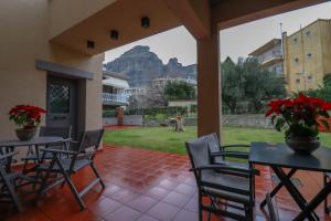 a patio with tables and chairs and a mountain view at SaltHouse #1 in Kalabaka