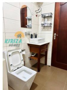 a bathroom with a toilet and a sink at Kiriza Homes in Bulindo