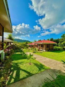 a house with a palm tree in the yard at LUZVILLE Transient House - Port Barton in Itaytay