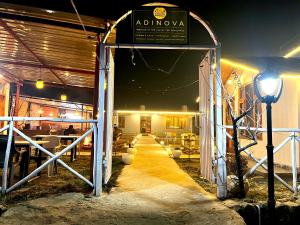 a restaurant at night with a sign on the door at Adinova in Kasol