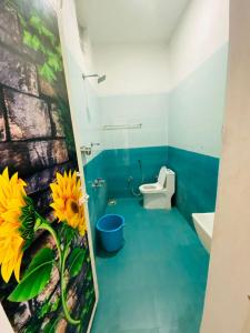 een badkamer met een toilet en een bloem op de muur bij Reho Resort 