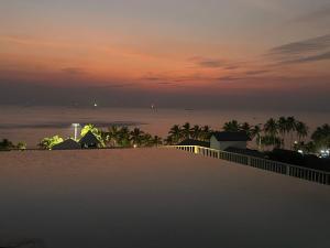 a view of the ocean at night from a balcony at The Patio bangsaen miracle Seaview in Ban Bang Saen (1)