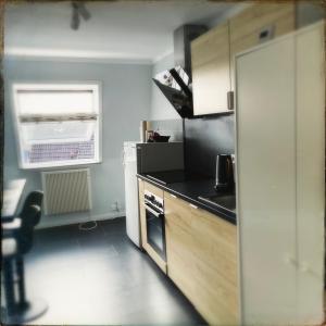 a small kitchen with a stove and a refrigerator at Schöne Penthousewohnung mit Weitblick in Arnsberg